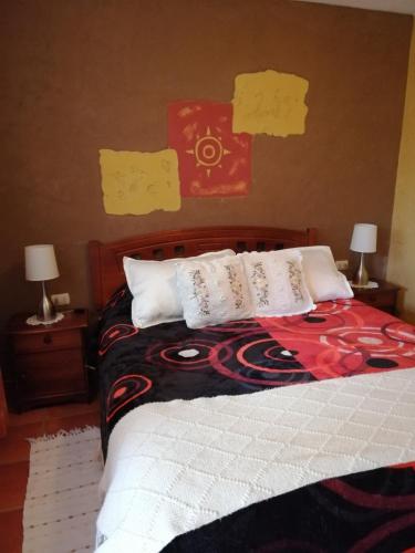 a bedroom with a bed with two night stands and two lamps at Hostal Apuwara in Combarbalá