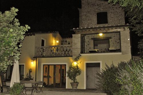 a large white house with a balcony at night at B&B and Wellness Il Pomario di Montepiglio Resort Naturista in Amelia