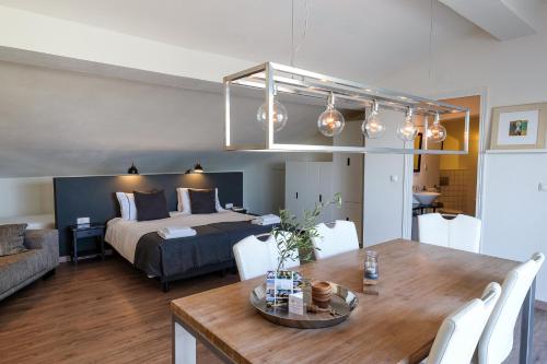 a living room with a bed and a dining room table at Casa Verdazul in Tavira