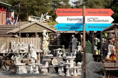 a group of statues and street signs in front of a store at Hof van Putten in Putten