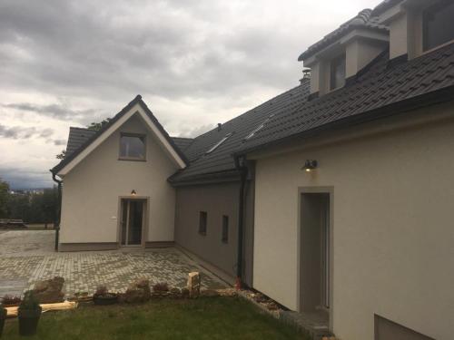 a white house with a roof and a yard at chalupa na Samotě s vířivkou in Tábor