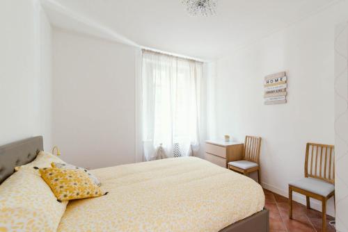 una camera da letto con un letto, una finestra e una sedia di Sunny Lake a Cernobbio