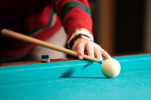 a man with a cue and a ball on a pool table at Hof van Putten in Putten