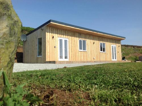 a small wooden building on top of a field at Island View Room 1 in Harlosh