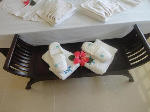 two towels and flip flops sitting on a bed at Le Relax Self Catering Apartment in La Digue