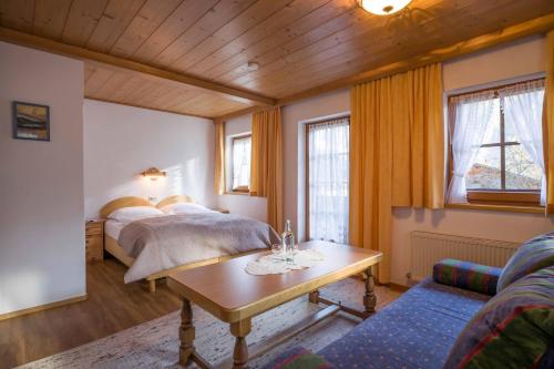 Chalet Walchenhof في مايرهوفن: غرفة نوم بسريرين وطاولة واريكة