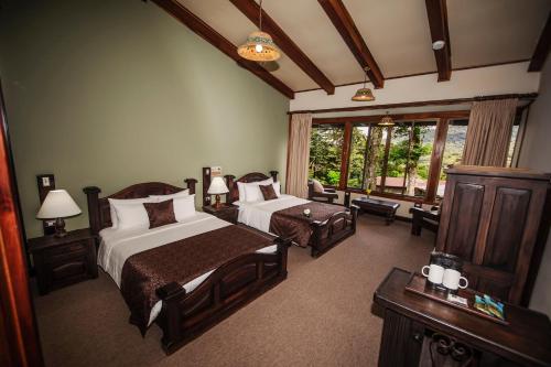 een slaapkamer met 2 bedden en een groot raam bij Trapp Family Lodge Monteverde in Monteverde Costa Rica