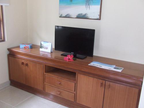 a wooden entertainment center with a flat screen tv on it at Le Relax Self Catering Apartment in La Digue