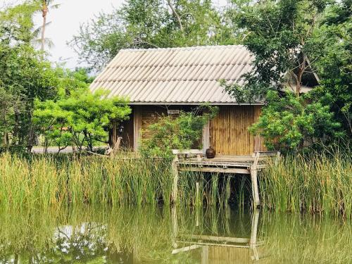 a small house on a dock next to a body of water at Numpu Baandin in Sam Roi Yot