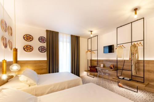 a hotel room with two beds and a mirror at Filinona B&B in Noto