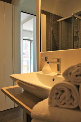 a bathroom with a sink and a mirror and towels at Residence Pola in Catania