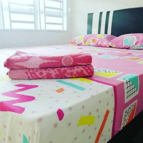 a bed with hello kitty sheets and pillows on it at Nur Zahra Sungkai Homestay in Sungkai