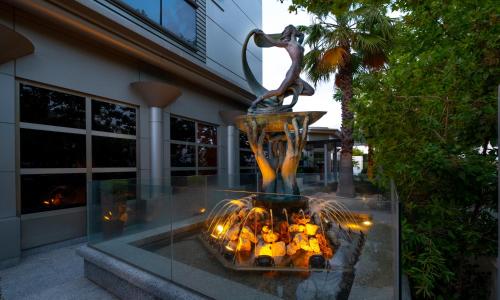 a statue of a woman standing over a fire in front of a building at Hotel Attica21 Las Rozas in Las Rozas de Madrid