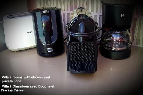 a counter top with a blender and a coffee maker at Villa centre Grand Baie in Grand Baie