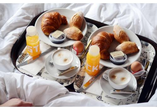 a tray of food with eggs and croissants on a bed at NAMAN HOTELLERIE - Margutta in Rome
