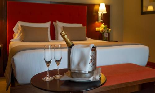 a hotel room with a bottle of champagne and two glasses at Hotel Attica21 Las Rozas in Las Rozas de Madrid