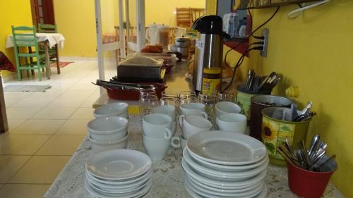 un grupo de tazas y platos blancos en un mostrador en Ipê Suites Juquehy, en Juquei