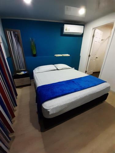 a bedroom with a bed with a blue wall at Palmare House in San Andrés