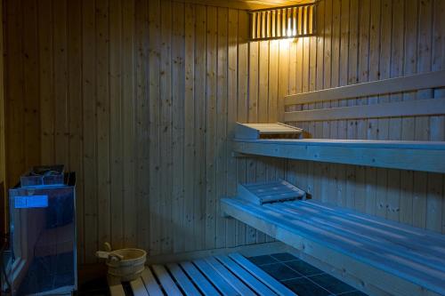 a sauna with a bench and a toilet in it at Hotel Ski&Sky in Predeal