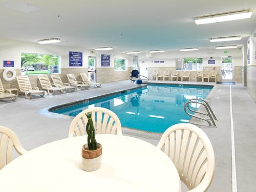 a large pool with chairs and a table and a table and a table at Crystal Inn Hotel & Suites - West Valley City in West Valley City