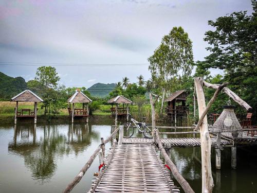 a bridge over a river with a bike on it at Numpu Baandin in Sam Roi Yot