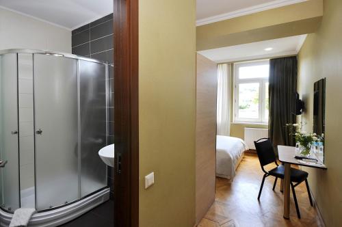 La salle de bains est pourvue d'une douche, d'un lavabo et d'un lit. dans l'établissement Hotel Frida, à Tbilissi