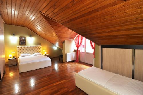 a bedroom with two beds and a wooden ceiling at Hotel Frida in Tbilisi City