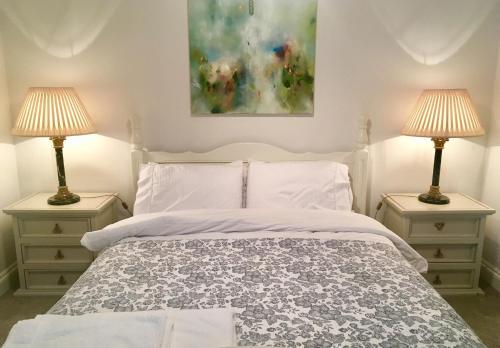een slaapkamer met een wit bed en 2 lampen bij Beautiful 1BR Apartment in Historic St Aubin House in Saint Aubin