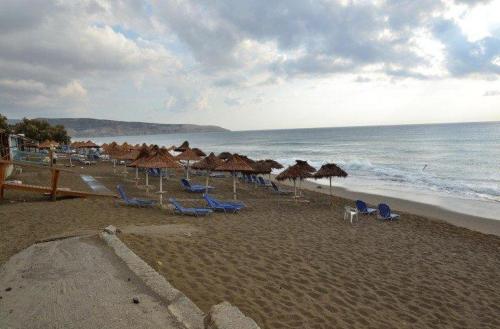 a beach with umbrellas and chairs and the ocean at Gaitani Village in Léntas