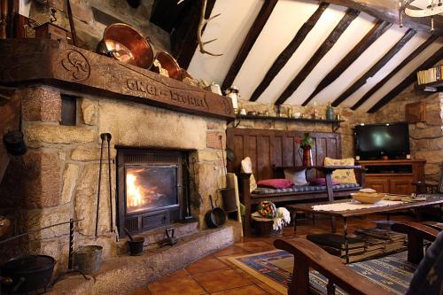 a living room with a stone fireplace and a table at CASA RURAL Urruska in Elizondo