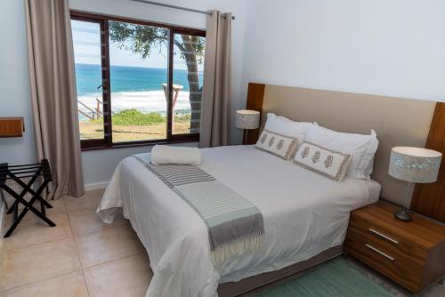 a bedroom with a bed with a view of the ocean at Brenton Breakers in Brenton-on-Sea