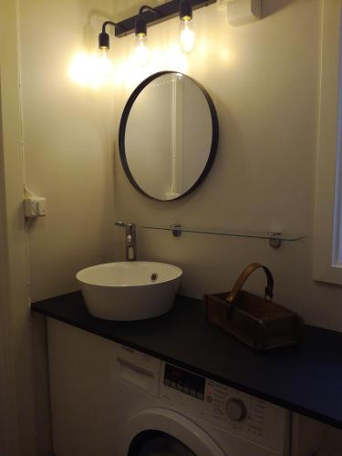 Un baño con lavabo y espejo sobre una lavadora. en Gårdshuset, en Söderhamn
