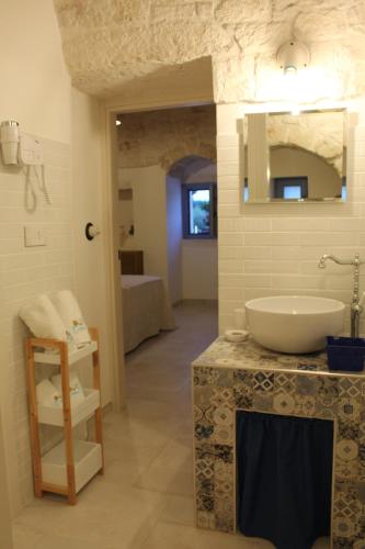 a bathroom with a sink and a mirror at TRULLI COLIBRI' in Locorotondo