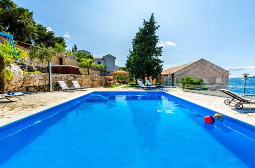 a blue swimming pool with a view of the ocean at Villa Gabriela in Korčula