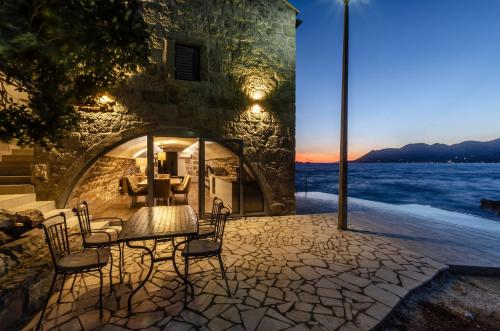 a patio with a table and chairs next to the water at Villa Gabriela in Korčula