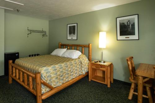 um quarto com uma cama e uma mesa com um candeeiro em The Kingsley Suites em Kingsley