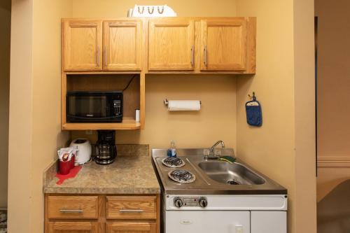 
a kitchen with a stove top oven and a sink at The Kingsley Motel in Kingsley
