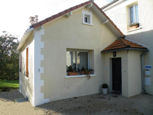 a small white house with a window and a door at La Villa Camille in La Creche
