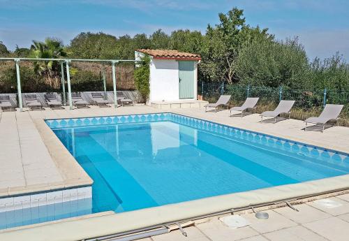 - une piscine avec des chaises et une maison dans l'établissement Mas Natura, à Banyuls-dels-Aspres