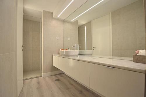 un bagno con un lavandino e un grande specchio di Apartamento das Malheiras a Viana do Castelo