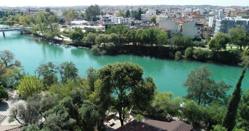 a view of a river with trees and buildings at River Hotel in Manavgat