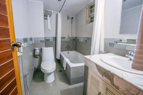 a bathroom with a toilet and a tub and a sink at Hotel La Villa Western by Sea Pearl Beach Resort & Spa in Dhaka