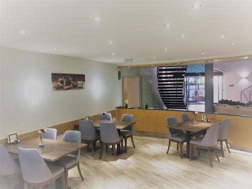 a restaurant with tables and chairs and a counter at A&M Hotel Barsinghausen in Bad Nenndorf