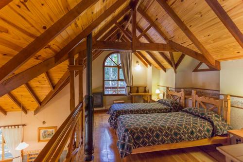 two beds in a room with wooden ceilings at Aldea Nevada in Ushuaia