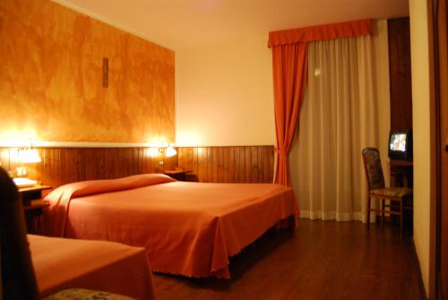 Un pat sau paturi într-o cameră la Albergo Villa Cristina