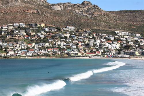 a view of a beach with a town in the background at South Peninsula Beach Apartment in Cape Town