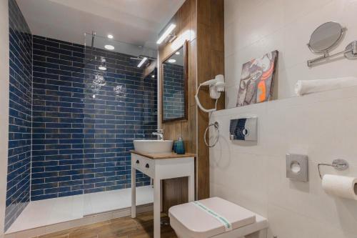 uma casa de banho com um WC, um lavatório e um chuveiro em Ares ApartHotel em Cluj-Napoca