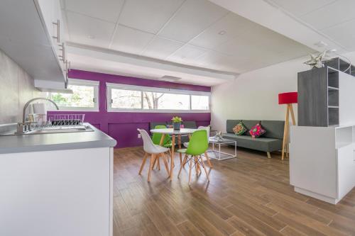 - une cuisine avec des murs violets, une table et des chaises dans l'établissement Deluxe Loft at Colonia ROMA, à Mexico