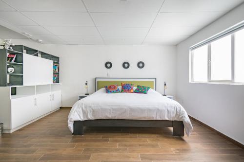 1 dormitorio con 1 cama grande en una habitación blanca en Deluxe Loft at Colonia ROMA, en Ciudad de México