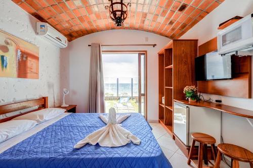 a bedroom with a bed with a blue bedspread at Village Paraíso in Florianópolis